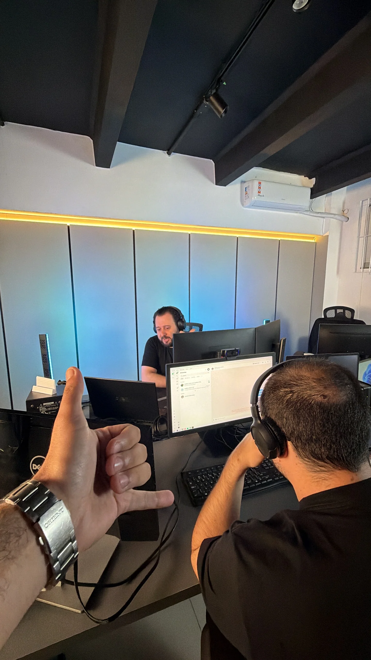 Bastidor de uma gravação com equipe, fones e monitores no estúdio.